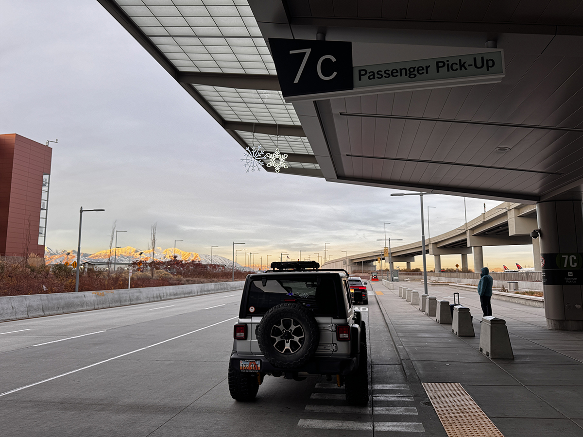 Silver Jeep parked at the SLC airport terminal